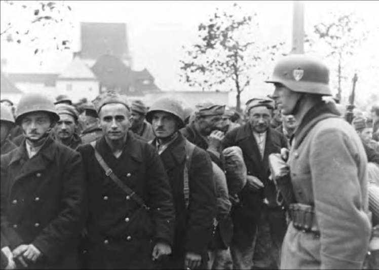 Немецкий солдат конвоирует польских солдат, захваченных в плен.